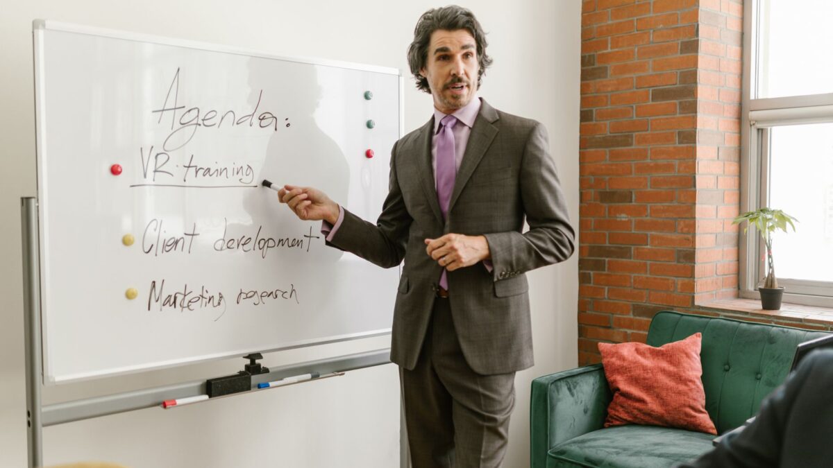 Conférencier animant une session de formation professionnelle devant un groupe attentif