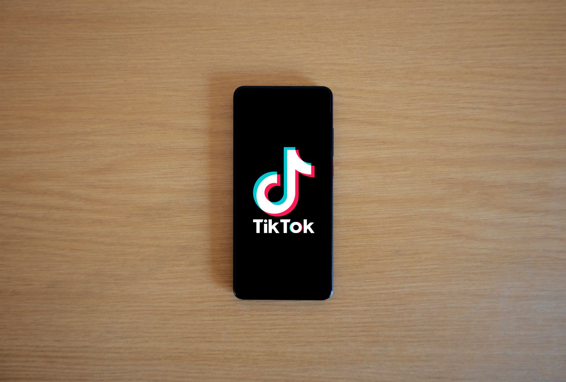 Entrepreneur utilisant TikTok sur smartphone pour promouvoir une TPE B2B et développer sa présence sur les réseaux sociaux