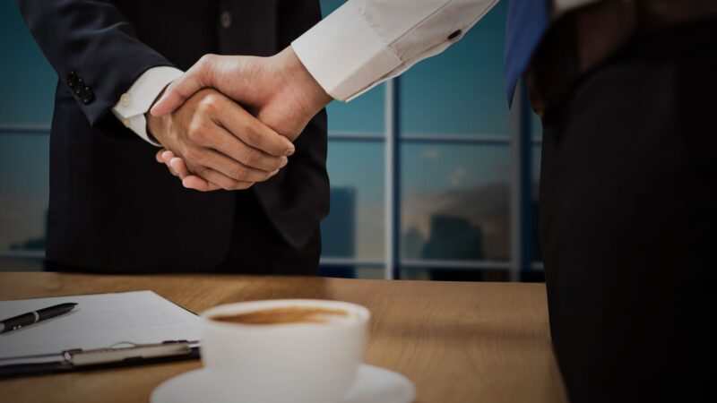 Homme d'affaires concluant une vente B2B avec succès en 2026 dans un bureau moderne