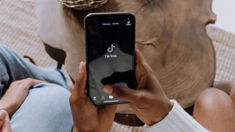 Homme d'affaires utilisant TikTok sur smartphone pour stratégie B2B et marketing d'entreprise