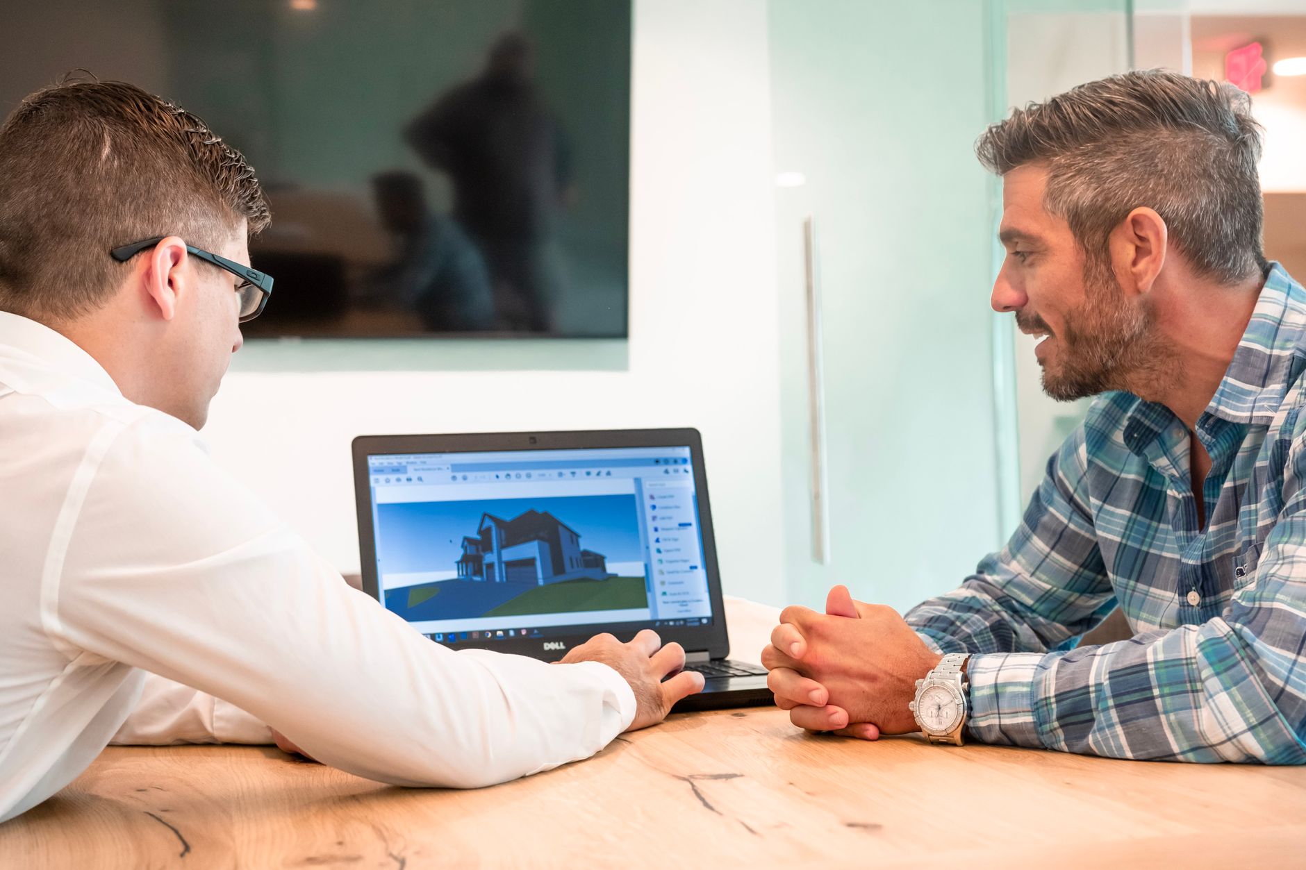 Architecte travaillant sur des plans dans un bureau moderne pour améliorer la visibilité locale et attirer des clients