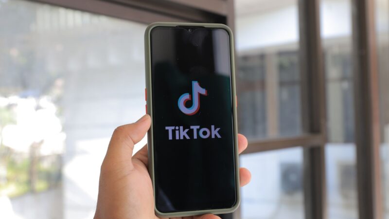 Homme d'affaires utilisant TikTok sur smartphone pour stratégie B2B en entreprise